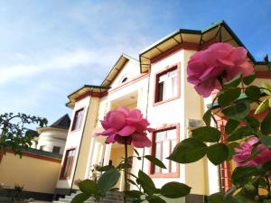 a building with pink flowers in front of it at Chinor Garden Hotel - Free Airport Pick-up and Drop-Off in Tashkent