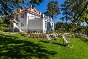 a group of lawn chairs in front of a house at Villa Testa in Sopot