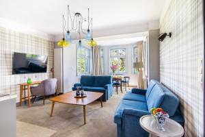 a living room with a blue couch and a table at Villa Testa in Sopot