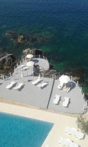 a group of chairs and umbrellas next to the ocean at Apartments Harmony in Utjeha