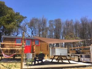 a tiny house with a tent and a swing at Moledos glamping in Aljezur