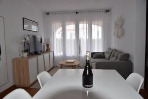 a bottle of wine on a table in a living room at Els Vents, tu apartamento junto al mar en Son Parc in Son Parc