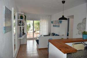 cocina y sala de estar con sofá y mesa en Els Vents, tu apartamento junto al mar en Son Parc, en Son Parc