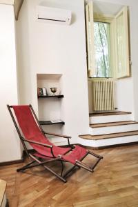 a red rocking chair sitting in a living room at Garden Suite at Palazzo Famularo in Lecce