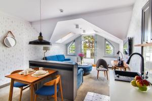 a kitchen and living room with blue chairs and a table at Villa Testa in Sopot