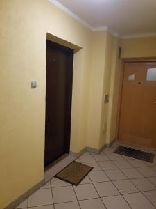 a hallway with a black door and a tile floor at Pod Jasną Górą - Apartament 3 in Częstochowa