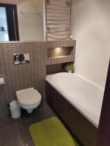 ein Badezimmer mit einer Badewanne, einem WC und einem Waschbecken in der Unterkunft Pod Jasną Górą - Apartament 3 in Częstochowa