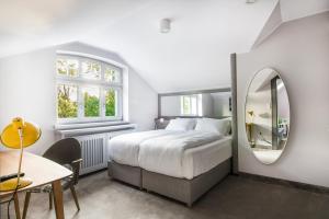 a bedroom with a bed and a mirror and a table at Villa Testa in Sopot