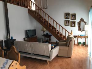 a living room with a couch and a staircase at Casa do Carroça in Terreiros