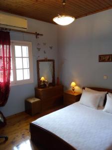 Schlafzimmer mit einem Bett, einem Spiegel und einem Fenster in der Unterkunft Villa Olive Garden, Kastanida - Paxoi in Gaios