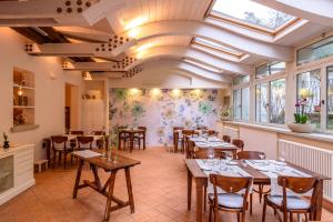 a restaurant with tables and chairs in a room with windows at La locanda del Povero Diavolo in Torriana