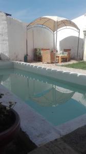 a swimming pool with an umbrella in a yard at villa alejada de aglomeraciones in Zaragoza