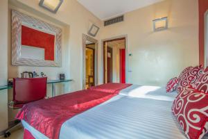 a bedroom with a bed with a red and white bedspread at La Griffe Hotel Roma in Rome