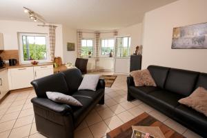 a living room with two couches and a kitchen at Ferienwohnung Panorama-Blick in Ulmen