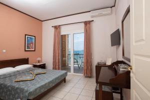 a hotel room with a bed and a balcony at Methoni Beach Hotel in Methoni