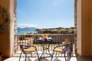 einen Balkon mit einem Tisch und Stühlen sowie Meerblick in der Unterkunft Methoni Beach Hotel in Methoni