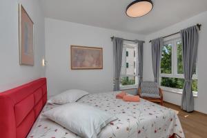 a bedroom with a bed and a red couch at Apartment Mediteraneo in Makarska +70 photos