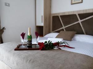 ウルツィニにあるApartments Gaziのベッドの上にシャンパン1本と花をトレイ