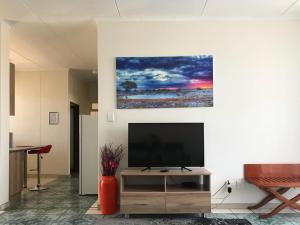 uma sala de estar com uma televisão de ecrã plano na parede em Home Inn Self-Catering em Windhoek