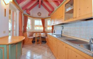 a kitchen with wooden cabinets and a table in it at Villetta Enrosadira in Vigo di Fassa
