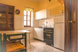 een keuken met een witte koelkast en een fornuis bij Agriturismo L.B.STUD in Bracciano