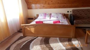 シオーフォクにあるÁdám Vendégház 2のベッドルーム1室(ピンクの枕が備わる木製ベッド1台付)