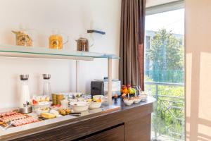 a buffet with food on a counter with a window at Best Western Hôtel Journel Antibes Juan-les-Pins in Antibes
