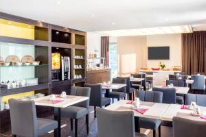 a restaurant with tables and chairs and a kitchen at Best Western Hôtel Journel Antibes Juan-les-Pins in Antibes