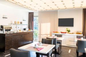 a restaurant with tables and chairs and a kitchen at Best Western Hôtel Journel Antibes Juan-les-Pins in Antibes