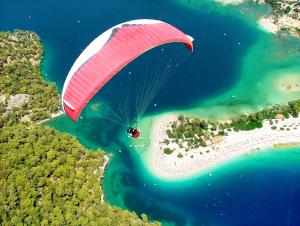 a person riding a parachute over a body of water at Sundia By Liberty Oludeniz in Oludeniz