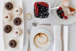 stół z filiżanką kawy i talerzem deserów w obiekcie Trampolines Suite Hotel w mieście Riccione