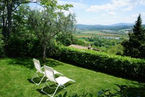 twee witte stoelen in een grasveld bij La Grande Finestra - Appartamento con giardino in Chiusi