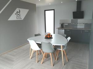 a white dining room table and chairs in a kitchen at Le Temps d'un Rêve in Eauze