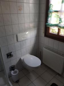 a white bathroom with a toilet and a window at Ferienwohnung Hampel in Eisenach