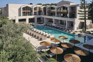 una piscina con sombrillas y sillas y un edificio en Contessina Hotel en Tsilivi