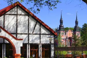 a building with a church in the background at Hotel Taurus in Święta Lipka