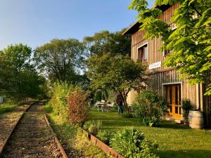 a train track next to a building and a house at Ferienwohnung im historischen Bahnhof in Kletkamp