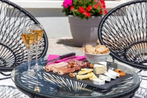 a glass table with a plate of food and a glass of wine at Best Western Hôtel Journel Antibes Juan-les-Pins in Antibes