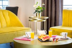 a table with a tray of food and orange juice at Best Western Hôtel Journel Antibes Juan-les-Pins in Antibes