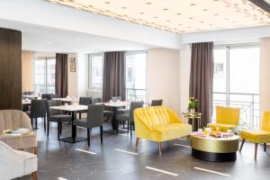 a dining room with tables and chairs and windows at Best Western Hôtel Journel Antibes Juan-les-Pins in Antibes