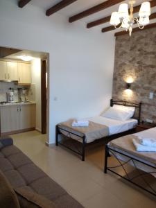 a living room with two beds and a kitchen at Casa del centro in Kardámyla