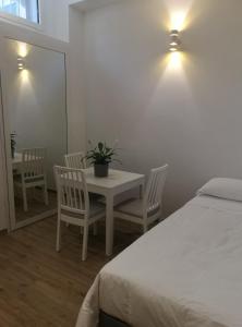 um quarto com uma mesa, cadeiras e uma cama em Apartments For You em San Donato Milanese