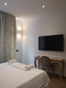 Habitación de hotel con cama y escritorio con TV. en Apartments For You, en San Donato Milanese