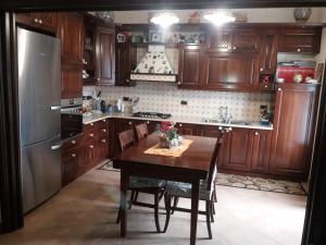 a kitchen with a wooden table and a refrigerator at Villino Maria - Beach Lodge in Torre Faro