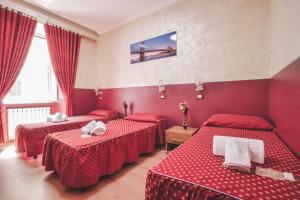 a hotel room with four beds in a red room at Vertex Homes in Rome