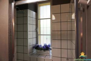 a mirror in a bathroom with a window with purple flowers at Primo Passo Apartments in Arco