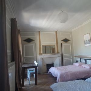 a bedroom with two beds and a fireplace at Relais des castors in Murat