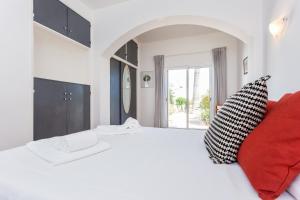 a bedroom with a large white bed with red pillows at Casa Furneaux by Seewest in Lagos