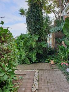 una pasarela de ladrillo en un jardín con plantas en Ocean Breeze, en Mossel Bay 14 fotos más