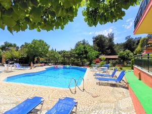 a swimming pool with blue chairs in a resort at Zako Apartments in Limenaria